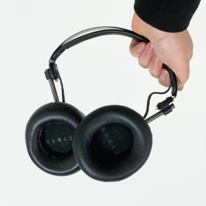 a transparent white background over an image of a set of head phones held by a white hand. Orange text reads “Zero Waste 101: Mending”